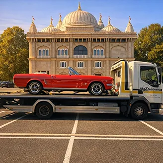 Red Mustang being transported on flatbed recovery truck serving A1, North London